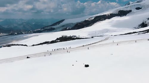 Group of People Climbs Snowy Mountains of Elbrus Along Road