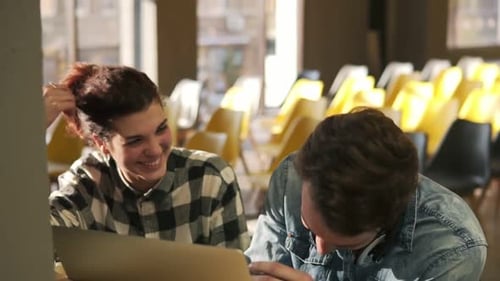 Young Adults Working Together on Laptop in Office