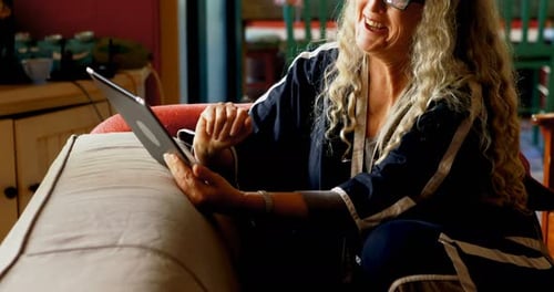 Woman Uses Tablet on Couch at Home