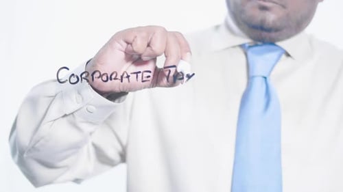 Man Writes Corporate Taxes on Transparent Surface