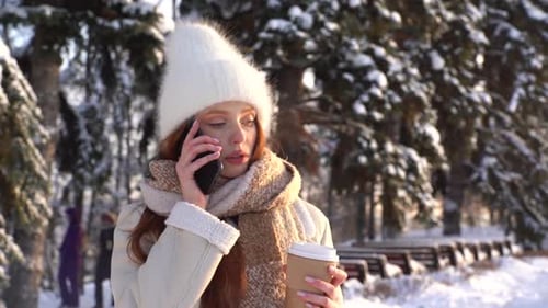 Woman Talking on Phone in Snowy Winter Park