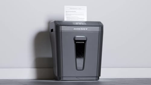 Shredding important documents. Side view at paper shredder working. Office. 4KHD