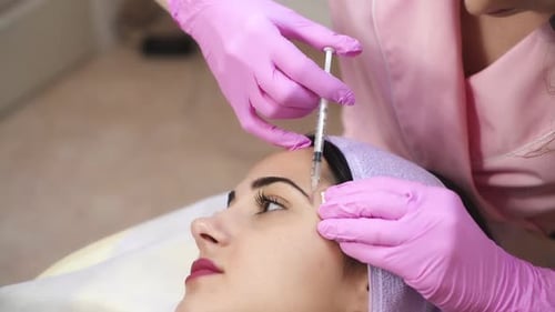 Person Receiving Injection on Face in Medical Setting