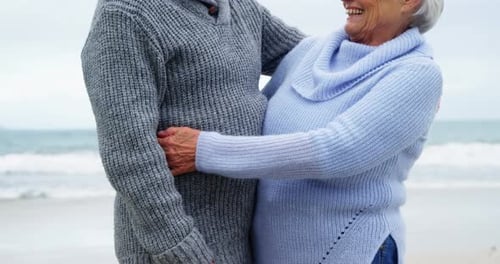 Senior Couple Embracing on Beach expressing love
