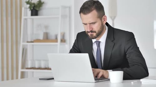Man in Suit Working at Computer Frustrated