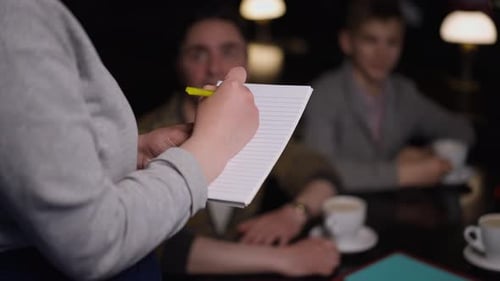 Closeup Unrecognizable Waitress Hand Writing with Pen in Slow Motion Receiving Order in Restaurant