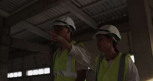 Industrial Engineers In Hard Hat Wearing Safety Jacket Working In The Building Site.