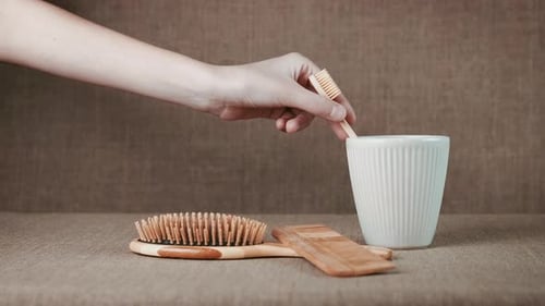 Eco comb. A woman use an eco toothbrash and combs in the room.