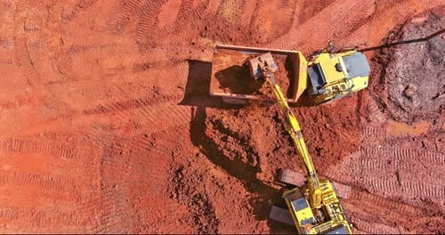 Aerial Top Down View of an Excavator Loading Earth Into a Dump Truck