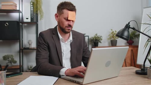 Adult Man Working with 'Loser' Note on Forehead