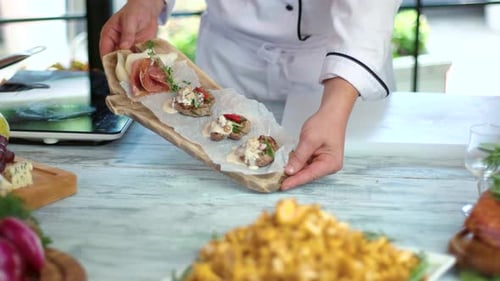 Chef Holding Serving Board with Gourmet Appetizers