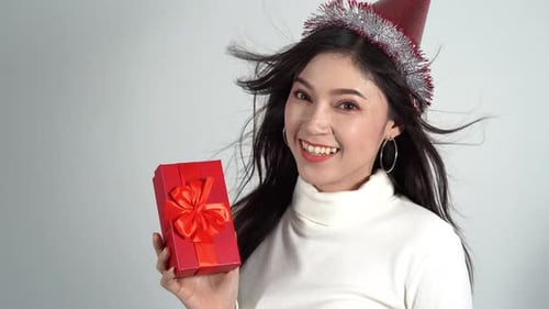 Smiling Woman Holding Red Gift With Festive Hat