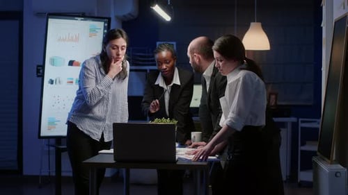 Colleagues Analyzing Data in the Office at Night