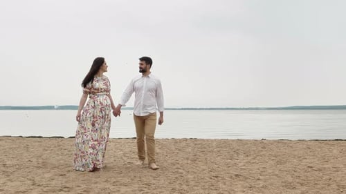 Romantic Couple Holding Hands Walking on Beach