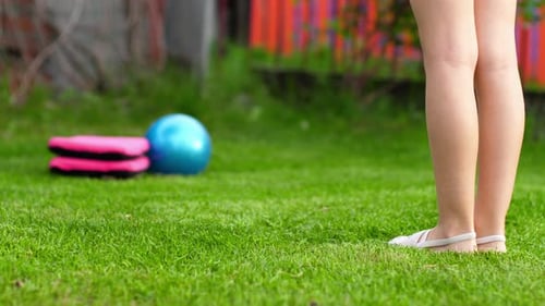 Woman Exercising on Lawn Performing Heel Raises