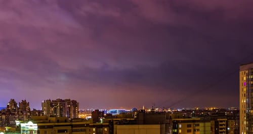 Night Cityscape with Illuminated Buildings and Cloudscape