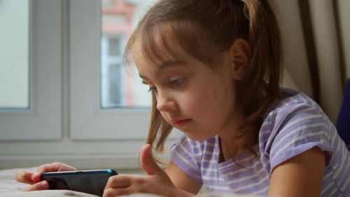 Girl Lying on Bed Using Smartphone