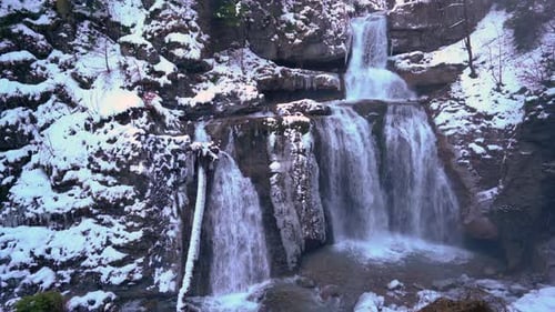 Icy Waterfall Flows in Winter Landscape