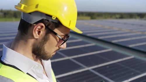 4K Professioneller Ingenieur mit digitalem Tablet zur Wartung von Solarzellenmodulen auf dem Dach des Gebäudes