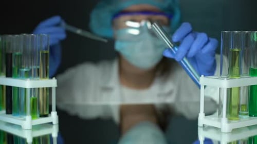 Chemiker fügt ölige Substanz in das Röhrchen mit blauer Testflüssigkeit hinzu, Lösungsmittelanalyse