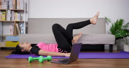 Woman Exercising Legs Lying Down at Home