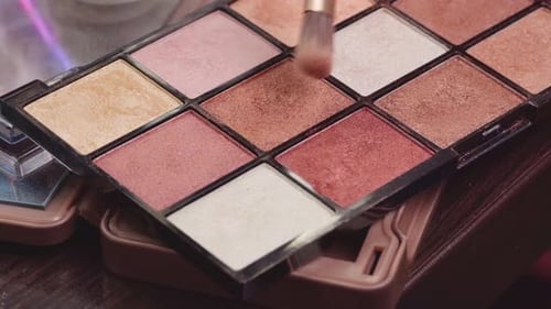 Primer plano de la paleta de brochas de maquillaje y sombras de ojos sobre el tocador