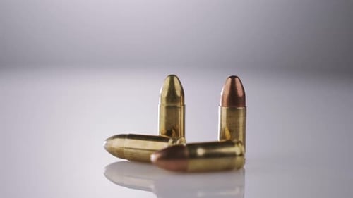 Shiny Bullets Rotate on White Surface