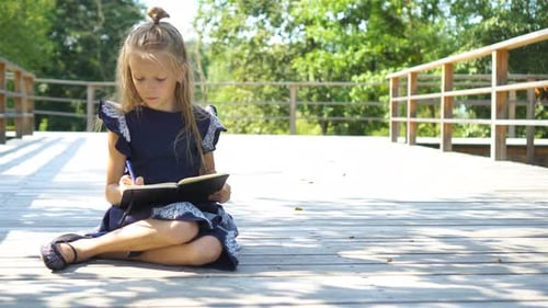 Adorable Little School Girl with Notes and Pencils Outdoor. Back To School.