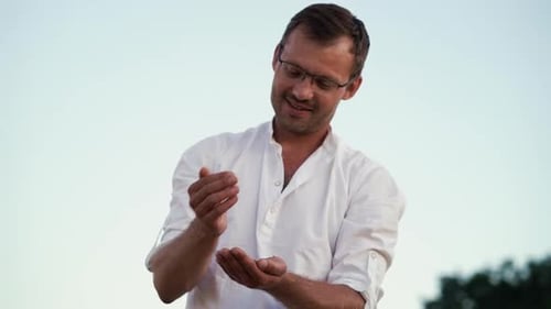 Farmland expert pouring handful of crops in wheat field in harvest season
