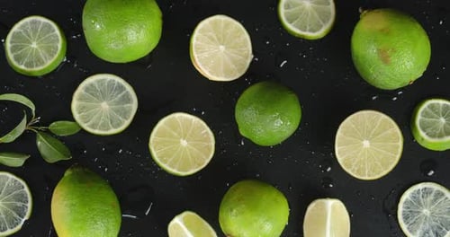 Fresh Limes Scattered on a Black Surface