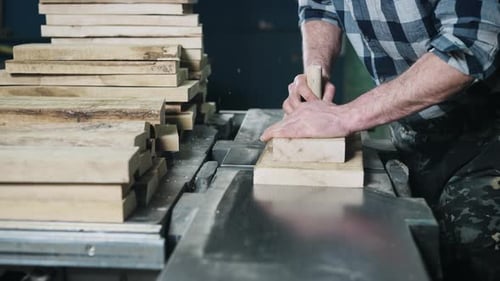 Man Operating a Wood Cutting Machine in a Factory