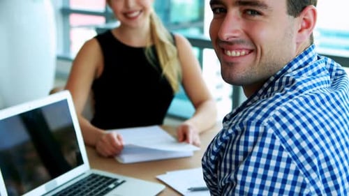Executives smiling at desk in office