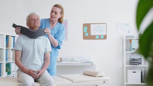 Medical Professional Fitting Cervical Collar on Patient