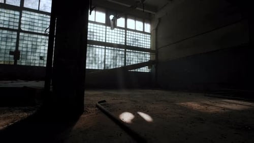 Interior industrial abandonado en colores oscuros en un día soleado y con los rayos del sol