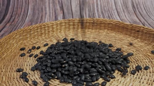 Dried Black Beans Poured Onto Woven Plate