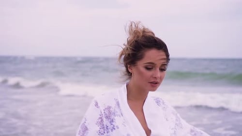 Girl Walks on the Beach on the Background of the Sea