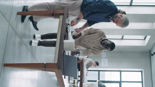 Young and Senior Multiethnic Architects Discussing Floor Plan