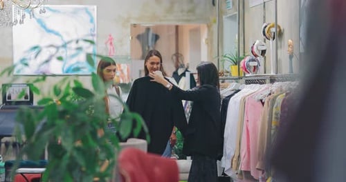 Garotas elegantes olham roupas em uma boutique