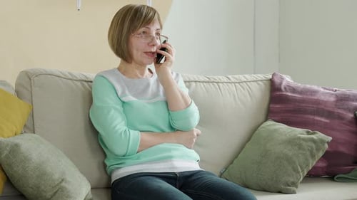 Woman Talking on Cellphone While Sitting on Couch