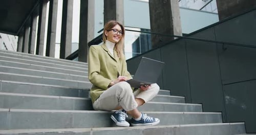 Happy Woman Working on Laptop on Urban Steps