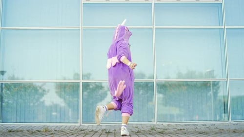 Woman Dances in Unicorn Costume in Urban Setting