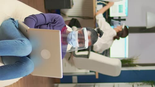 Vertical Video African Employee with Visor Sitting on Armchair in Middle of Office