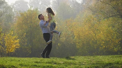 Father and Daughter Playfully Tossed in Autumn Park
