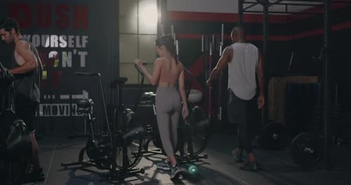 group fit during cardio cycling on air bike cross training at gym