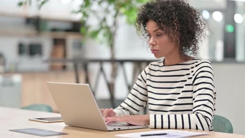 African Woman Working on Laptop in Office