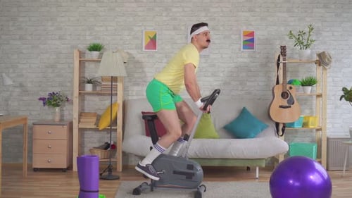 Man Exercising on Stationary Bike Indoors