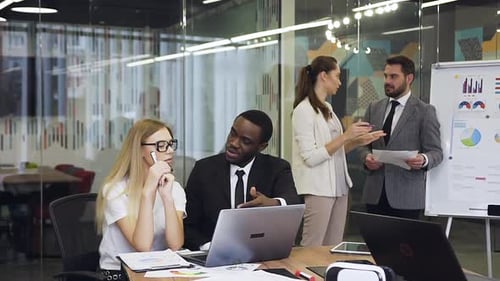 Adults Collaborate in Modern Office Meeting