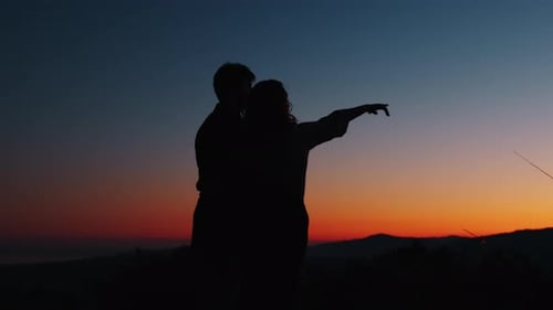 Affectionate Couple Silhouetted Against a Vibrant Sunset