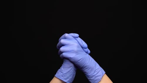 Gloved Hands Interlock on a Black Background