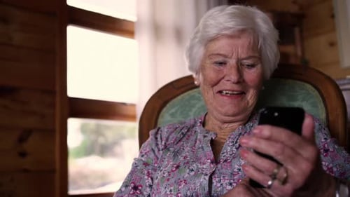 Senior Woman Using Smartphone in Living Room